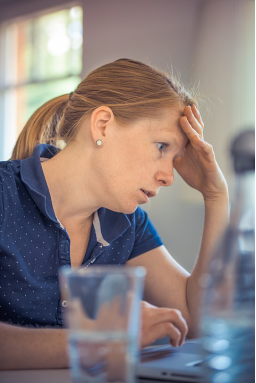 A woman holding her head and getting frustrated because of her ADHD condition.