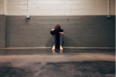 A person struggling with depression sitting in an isolated room alone