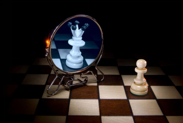 A pawn looking at a mirror displaying a queen, a conceptual image about the power of the subconscious