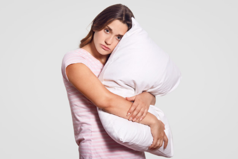 a sad woman hugging her pillow