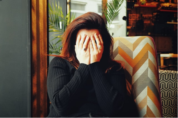 A woman covers her face with her hands