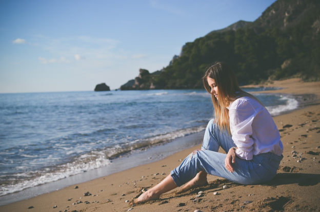 A woman sitting alone at a beach