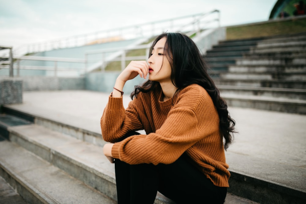 A woman sitting and thinking on the stairs