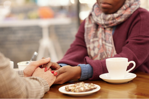 A man and woman holding hands over a table