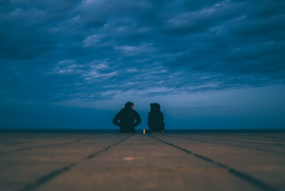 A couple sits together in a field