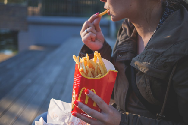 A woman eating unhealthy fast food