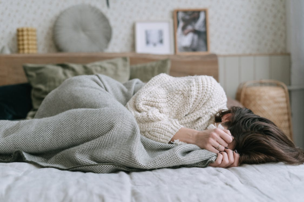 A woman lying in bed due to depression