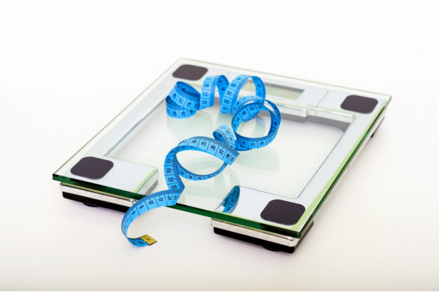 A blue measuring tape on a square glass weighing scale