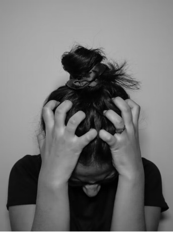 A woman yanks her hair, looking visibly stressed and anxious