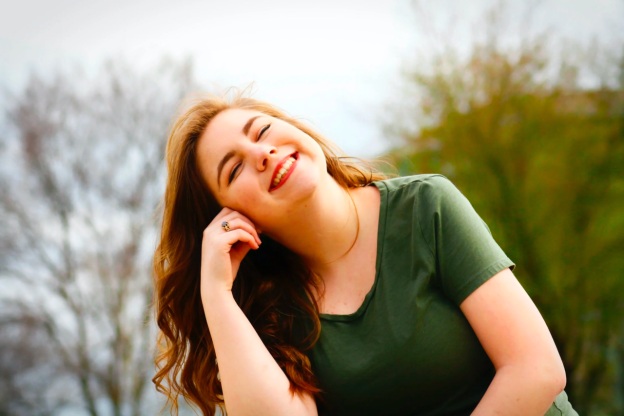 A young woman looks content and excited as she faces the sky