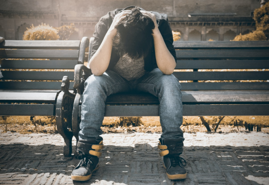 A person sitting frustrated on the bench