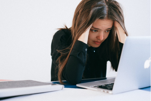 A stressed woman working on her laptop