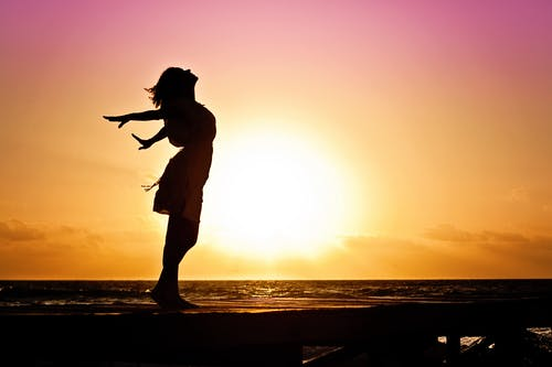 Lady in beach silhouette during daytime