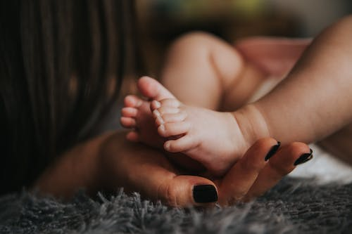 A mother holding her baby’s feet