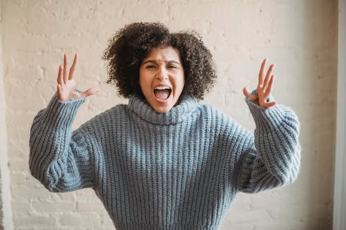 woman in blue sweater screaming