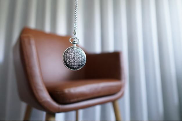 silver pendant hanging near a brown chair