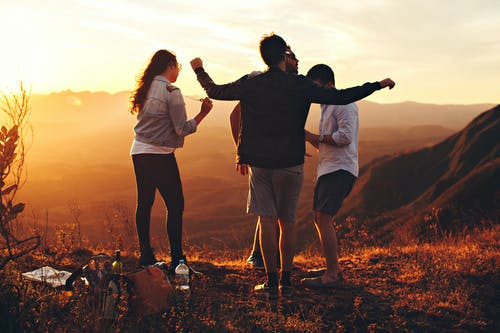 a group of teenagers hanging out near a cliff