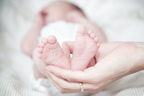 a mother holding her baby’s feet