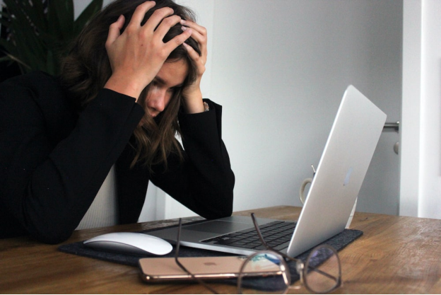 A person working on a laptop, looking very stressed