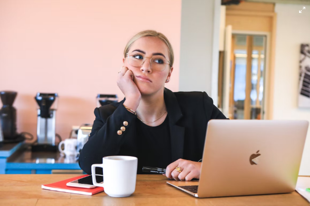 A person sitting in front of a laptop, not working