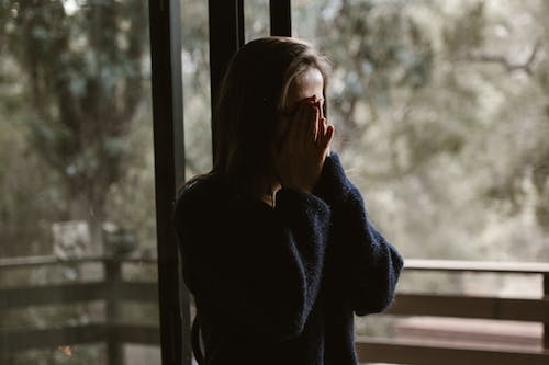 a woman covering her face with her hands