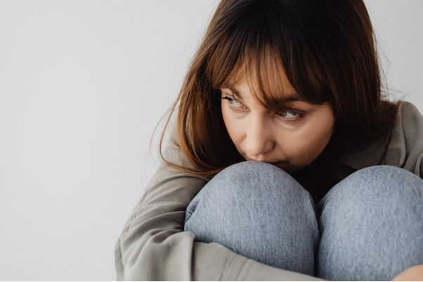 A person sitting while hugging their legs